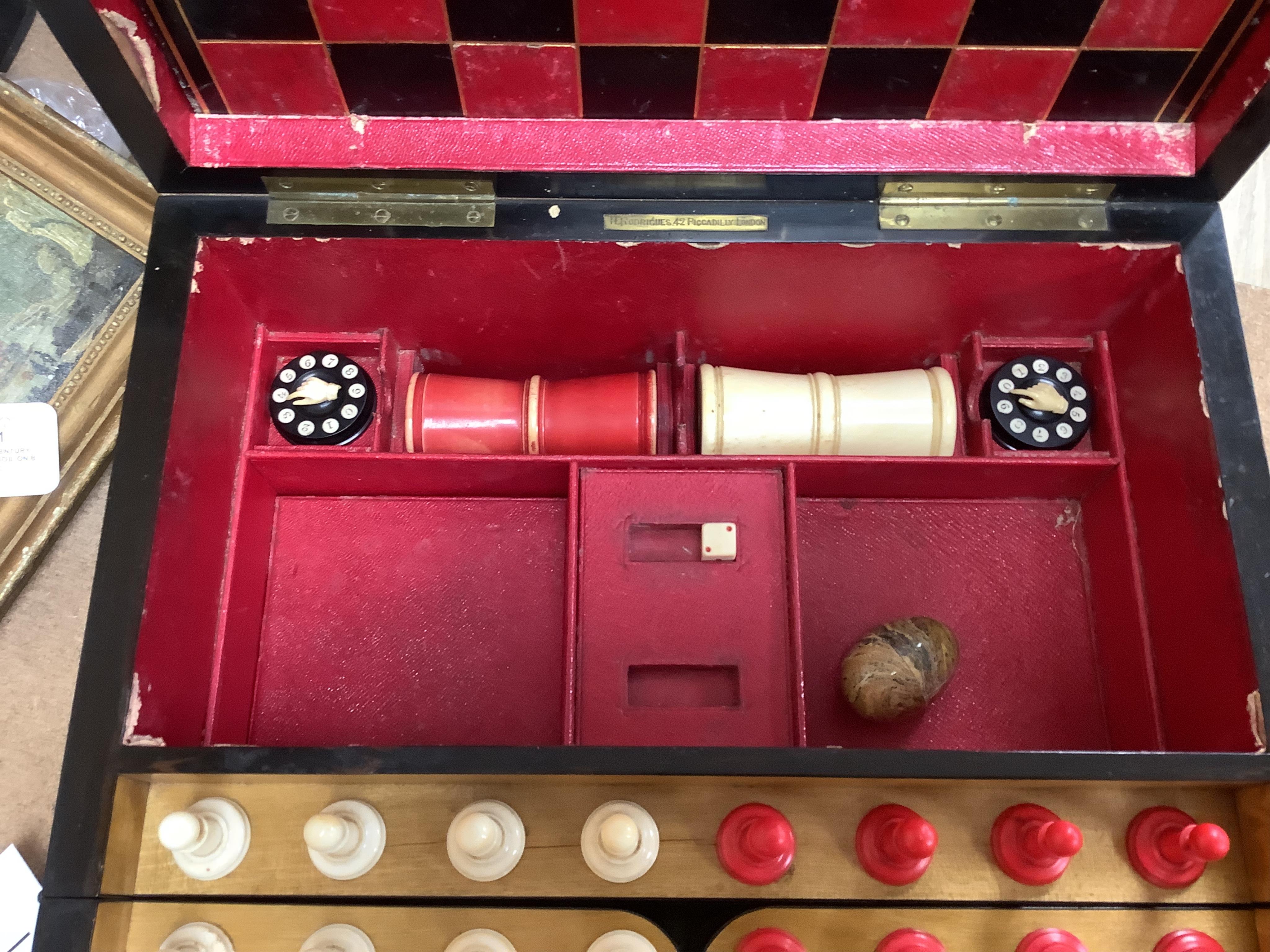 A Victorian coromandel games box with accessories, ivory chess pieces and counters, box 36cm wide x 19cm high. Condition - red interior leather worn and torn in places and box scratched, minor losses to chess pieces. CIT